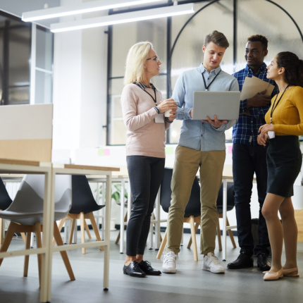 Colleagues Analyzing Online Data In Coworking Space